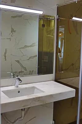 a bathroom with a sink and a shower and a mirror at Holiday House Kubrat in Sapareva Banya