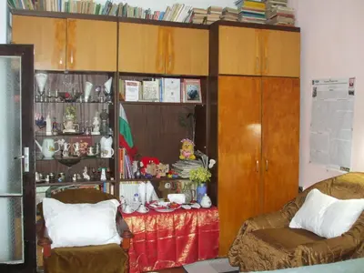 a living room with two chairs and a table and cabinets at Kamigs Rooms in Sofia