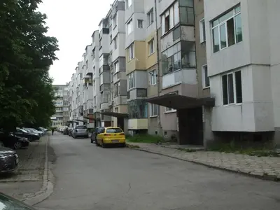 a yellow car parked on a street next to buildings at Kamigs Rooms in Sofia