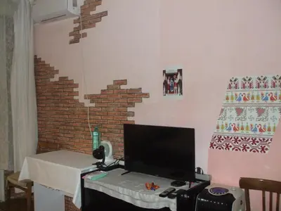 a desk with a computer in a room with a brick wall at Kamigs Rooms in Sofia