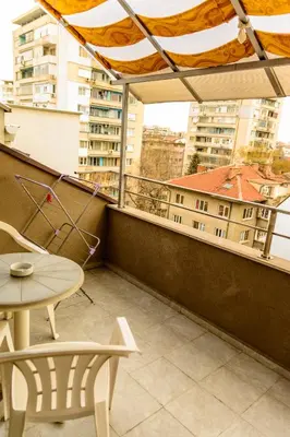 a balcony with a table and chairs and a view of buildings at Apartment Leonardo Da Vinci in Plovdiv