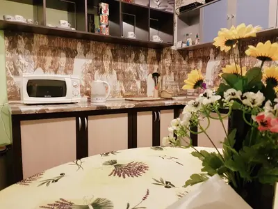 a kitchen with a counter with a microwave and flowers at Like Home Guest Rooms in Sofia
