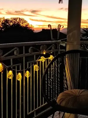 a bench sitting on a fence with lights at Guest House Emiliya in Ovchartsi