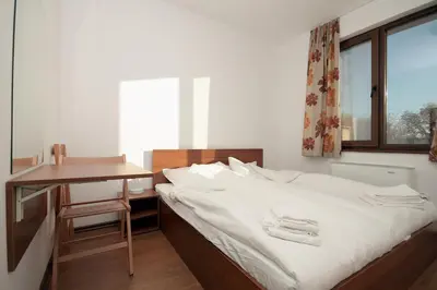 a bedroom with a bed with a desk and a window at Yan BibiYan Guest House in Negushevo