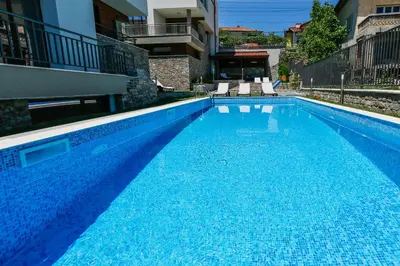 a large blue swimming pool with two chairs in a building at Twin House in Ognyanovo