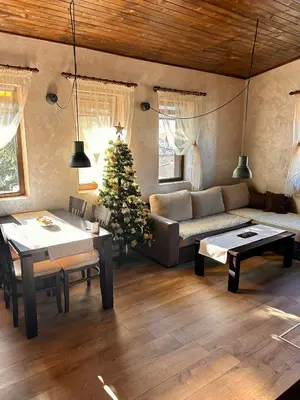 a living room with a couch and a christmas tree at Chepelare Holiday Guest House in Chepelare