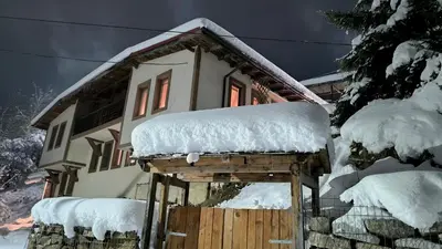 a house with snow on top of it at Chepelare Holiday Guest House in Chepelare