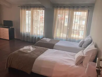 two beds in a hotel room with windows at Къща за гости Мегдана in Sopot