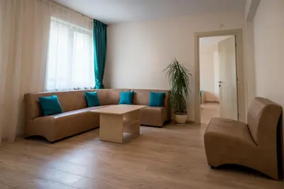 a living room with a brown couch and blue pillows at Youth Centre Plovdiv in Plovdiv