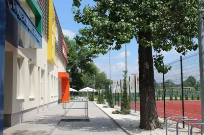 a building with a tennis court next to a tree at Youth Centre Plovdiv in Plovdiv
