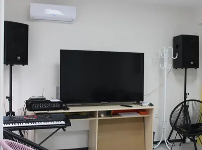 a television on a desk with a keyboard and speakers at Youth Centre Plovdiv in Plovdiv