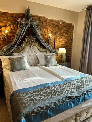 a bedroom with a large bed with a wooden wall at Valentina Castle in Ognyanovo