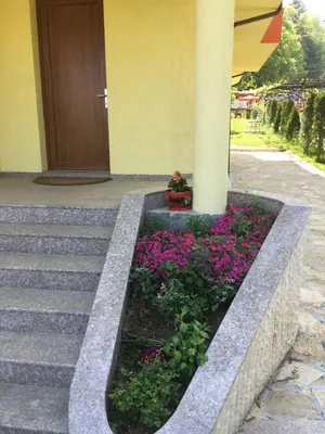 a flower bed in front of a building at Kot Garden Guest House in Sapareva Banya