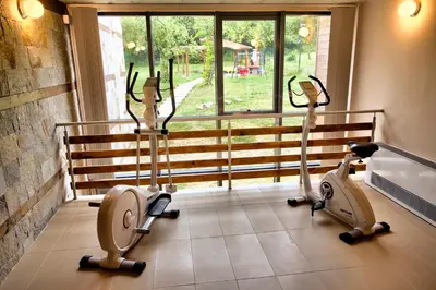 a gym with three exercise bikes in a room at Holiday Home Marta in Dobrevtsi