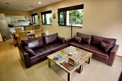 a living room with two leather couches and a table at Holiday Home Marta in Dobrevtsi