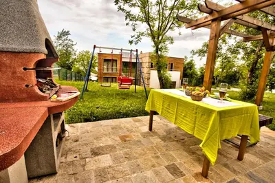 a table with a yellow table cloth sitting on a patio at Holiday Home Marta in Dobrevtsi