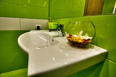 a bathroom sink with a vase with flowers in it at Holiday Home Marta in Dobrevtsi