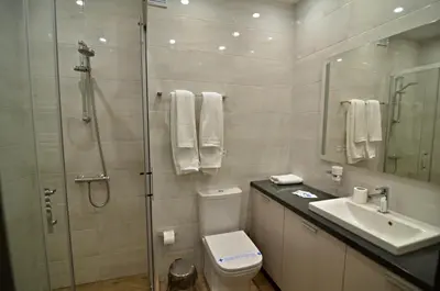 a bathroom with a shower and a toilet and a sink at Guest House Colori in Tsigov Chark