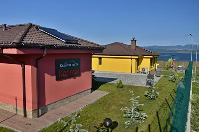 a building with a sign on the side of it at Guest House Colori in Tsigov Chark
