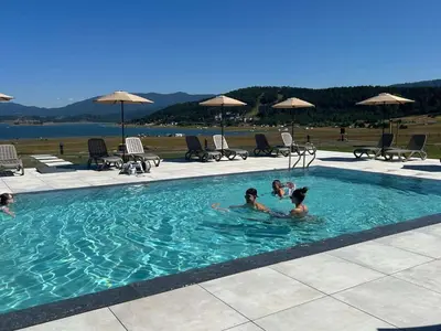 a group of people swimming in a swimming pool at Guest House Colori in Tsigov Chark