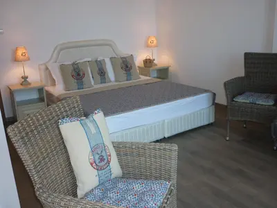 a bedroom with a bed and two chairs and a couch at Boomerang Guest House in Apriltsi