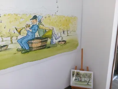 a painting of a man playing a trumpet on a wall at Boomerang Guest House in Apriltsi