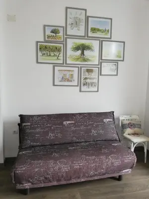a bed in a room with pictures on the wall at Boomerang Guest House in Apriltsi