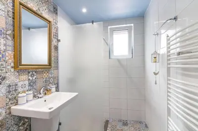 a white bathroom with a sink and a mirror at Domus Apartments City Center with Parking in Plovdiv