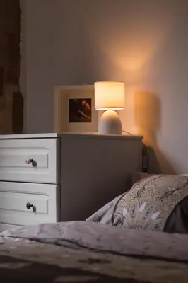 a bedroom with a dresser and a bed with a lamp at Domus Apartments City Center with Parking in Plovdiv