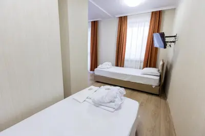 a hotel room with two beds and a mirror at Hotel Nikol in Dolna Banya