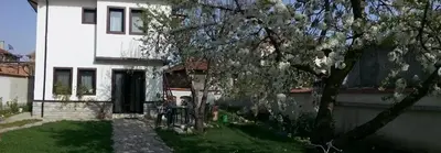 a white house with a tree in the yard at Bobekova Kashta in Panagyurishte