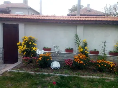 a house with a bunch of flowers in a yard at Bobekova Kashta in Panagyurishte