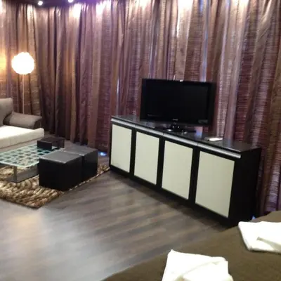 a living room with a flat screen tv and a couch at Studio Mountain Dreams Deluxe in Sapareva Banya