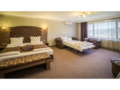 a hotel room with two beds and a couch at Park Hotel and SPA Vella Hills in Velingrad