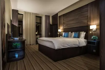 a hotel room with a large bed and a television at Premier Sofia Airport Hotel in Sofia