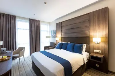 a hotel room with a large bed and a desk at Premier Sofia Airport Hotel in Sofia