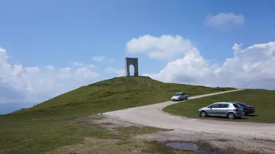 two cars parked on a hill with a monument at Pamir Guest House in Shipkovo