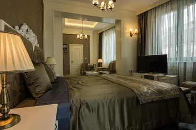 a bedroom with a large bed and a television at Boutique Guest House Coco in Plovdiv