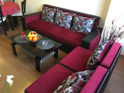 a living room with a red couch and a table at Oscar Wilde Apartment in Sofia