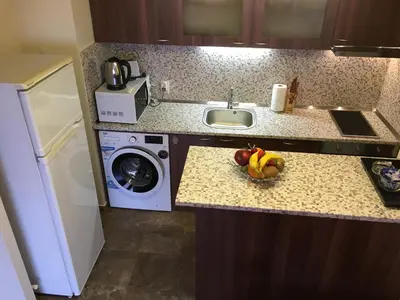 a kitchen with a sink and a bowl of fruit on a counter at Oscar Wilde Apartment in Sofia