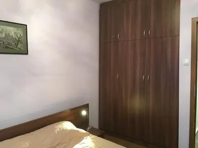a bedroom with a bed and a large wooden cabinet at Oscar Wilde Apartment in Sofia