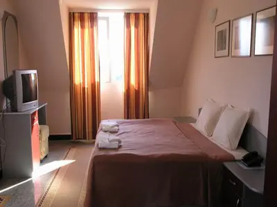 a hotel room with a bed and a television at Hotel Ertancom in Blagoevgrad