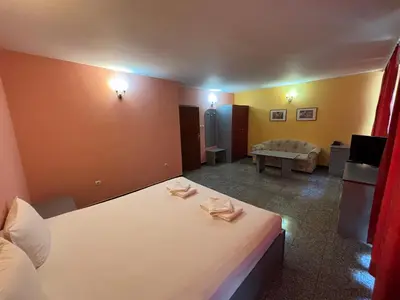 a hotel room with a bed and a couch at Hotel Ertancom in Blagoevgrad