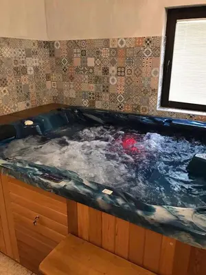 a large jacuzzi tub in a room at Hotel Kristal in Dospat