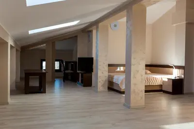 a bedroom with a bed and a desk and a television at Hotel Kristal in Dospat