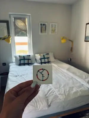 a person holding a sign in front of a bed at The Clock house in Samokov