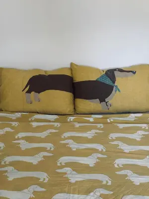a bed with two pillows with a dog on it at The Clock house in Samokov