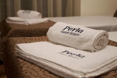 a pile of towels sitting on a table in a hotel room at Хотел PERLA in Strelcha