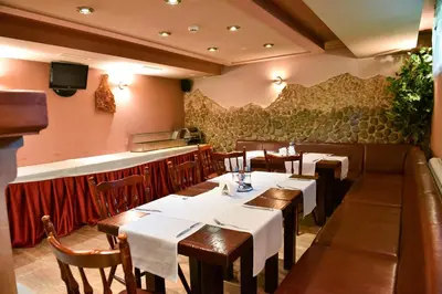 a restaurant with tables and chairs and a bar at Martin Club Hotel in Bansko