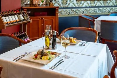 a table with two glasses of wine and a plate of food at Hotel Leipzig in Plovdiv